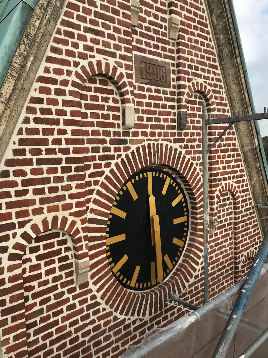 Restaurierte Kirchturmuhr mit Klinkermauerwerk